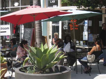 Photo: People seated at cafe tables on the new bulbouts.