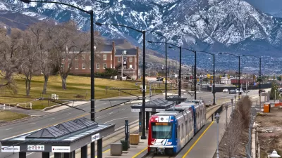 trax light rail train in foreground, snow-covered mountains in background