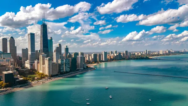 Aerial view of Chicago skyline on bright day with turquoise Lake Michigan in foreground.