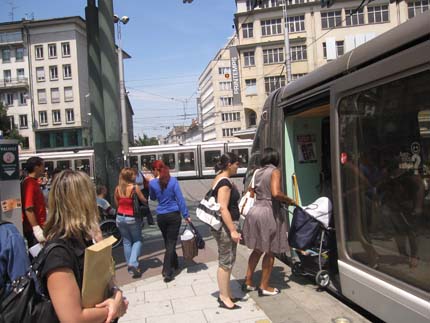 PHOTO: A woman with a stroller boards a tram.