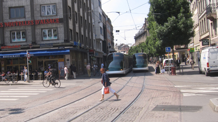 PHOTO: A woman walks in front of two trams.