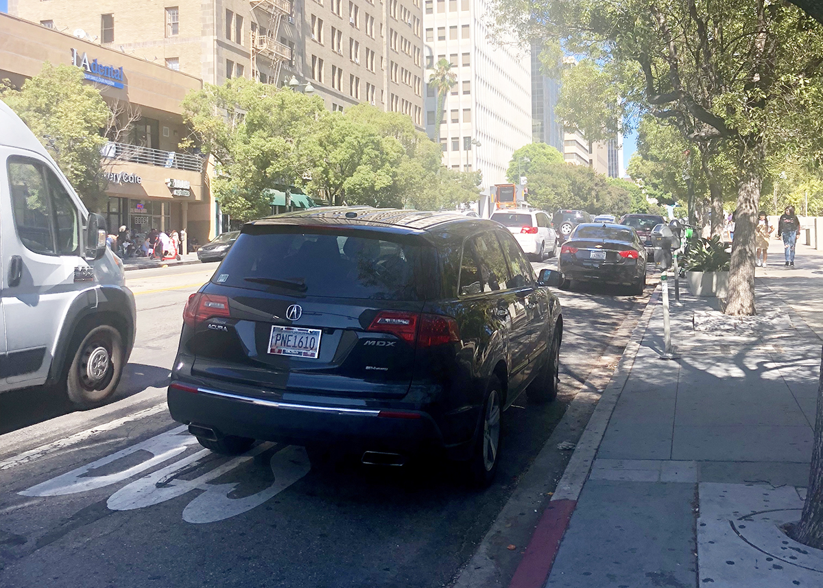 Numerous cars block a bus only lane on Wilshire Boulevard in Los Angeles