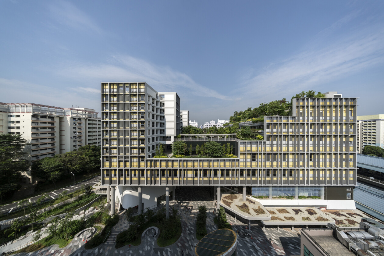 A large apartment building with trees on top of layered roofs.