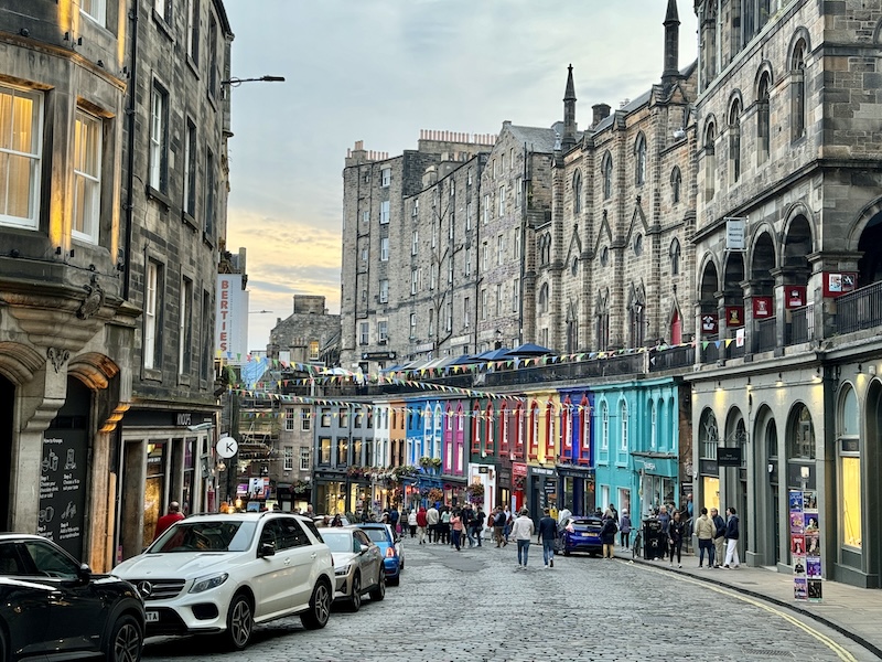 Busy street in Edinburgh, Scotland with medieval walls on either side.