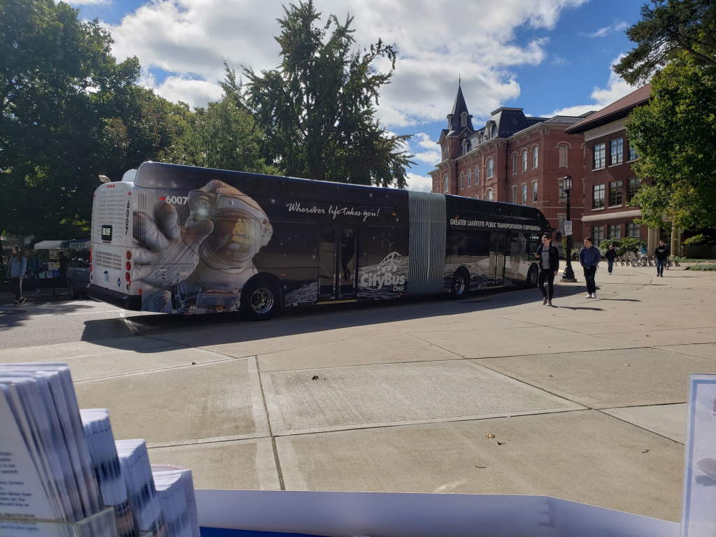 Articulated bus with advertising banner wrap.