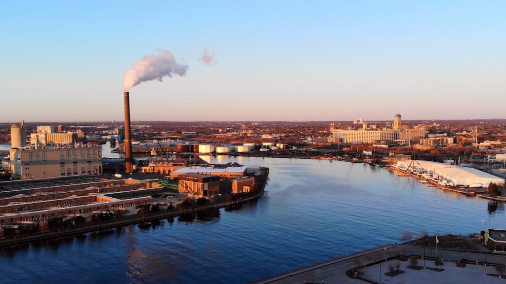Milwaukee Waterfront with a tall chimney on the left during Golden Hour.
