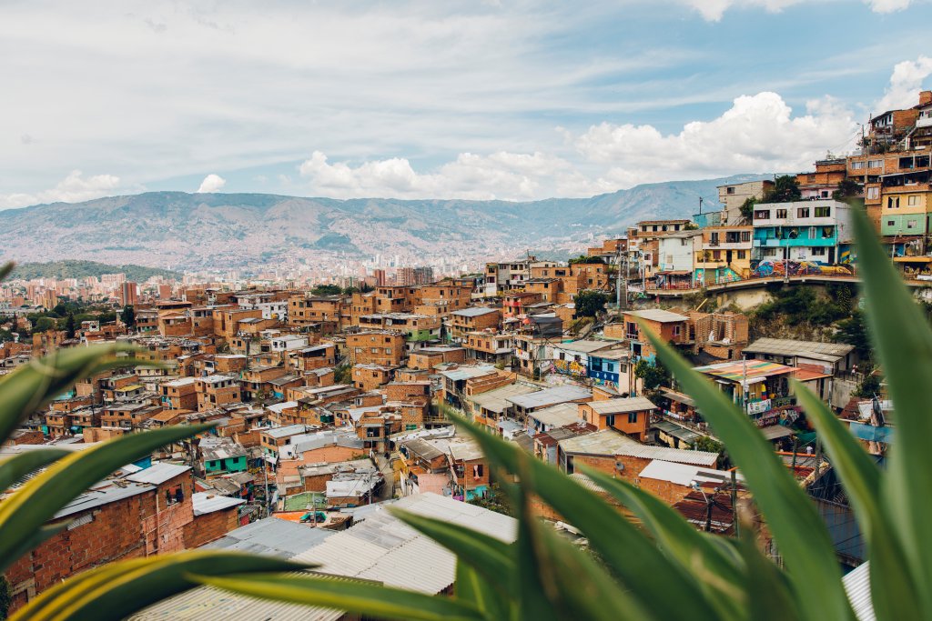 Mountain valley filled with hillside homes and surrounded by tropical mountains.