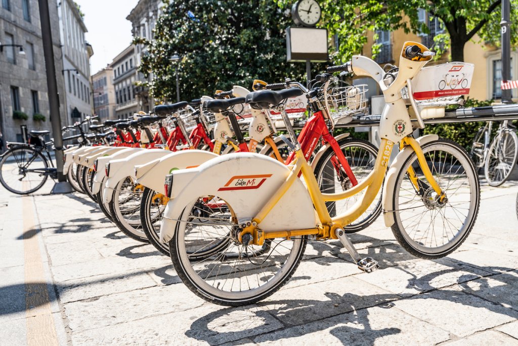 Bike share station with yellow and white bikes inMilan, Italy.