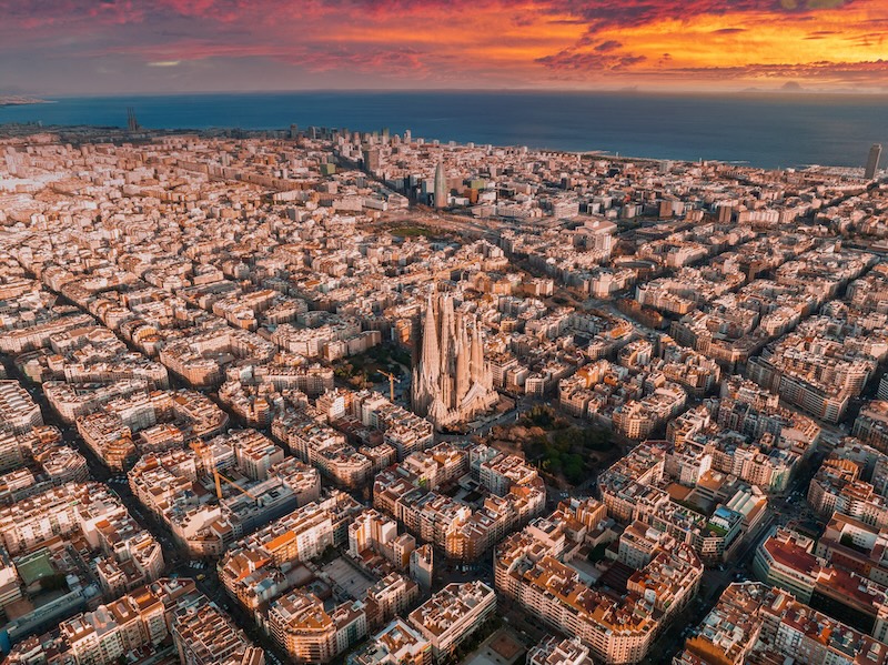 Aerial view of Barcelona City Skyline and Sagrada Familia Cathedral at sunset.