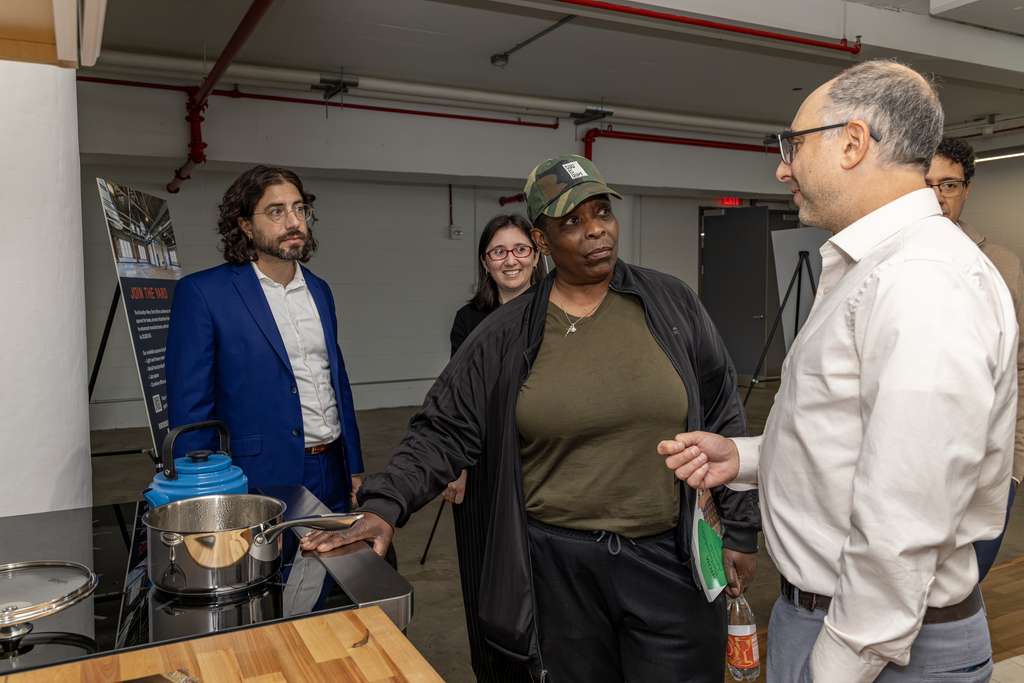four people look at an electric induction stove