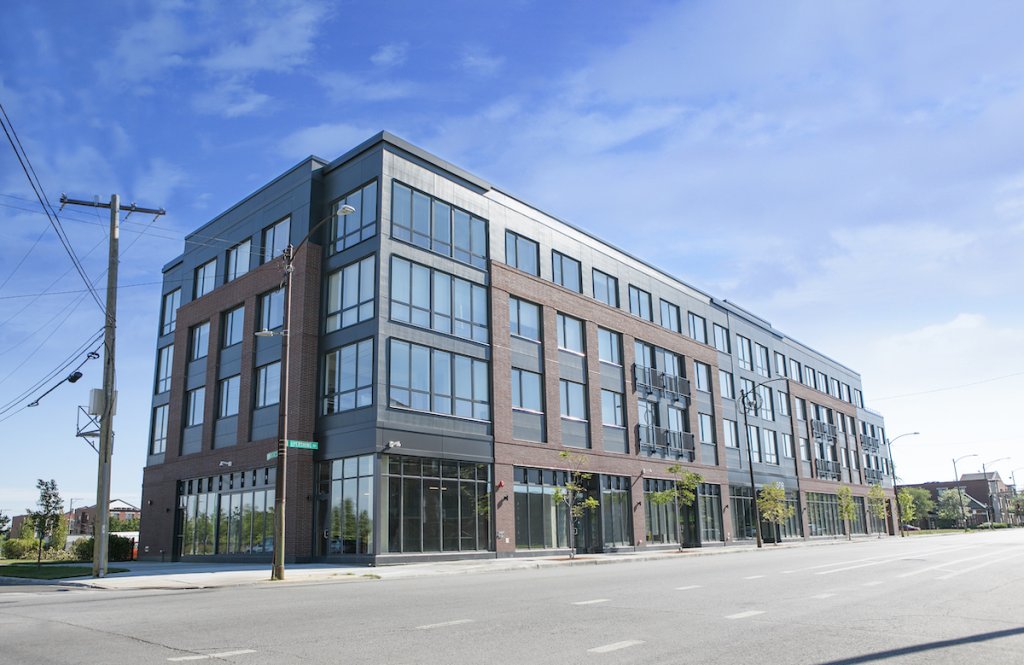 A large, multi-story building, newly constructed, pictured in the sublight.