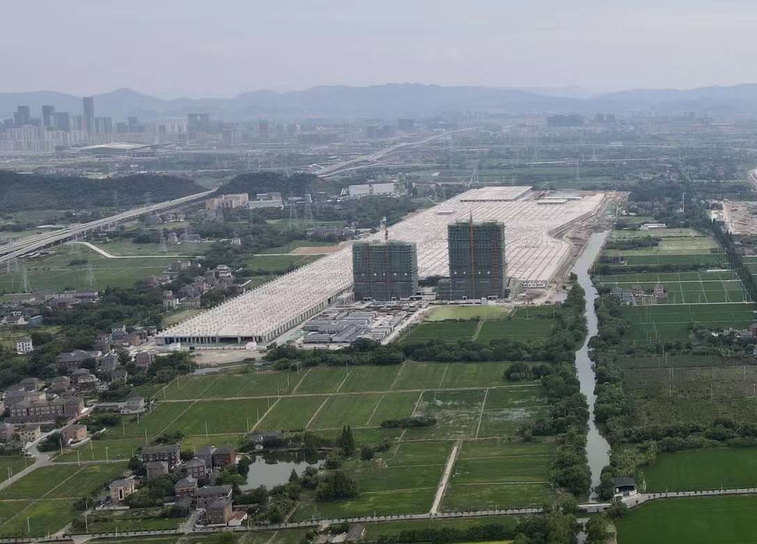 Cangqian Depot concrete deck over train depot in green fields in China.