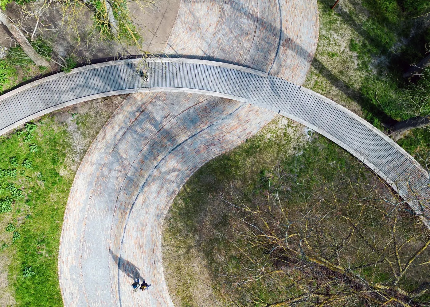 Bird's eye view of winding stone walkway and wooden walkway over it in park in Copenhagen, Denmark.