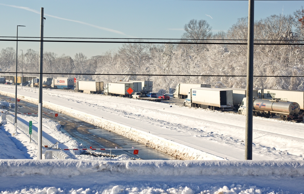 Vehicles Stuck in a traffic jam after a winter snow storm with snow covered roads.
