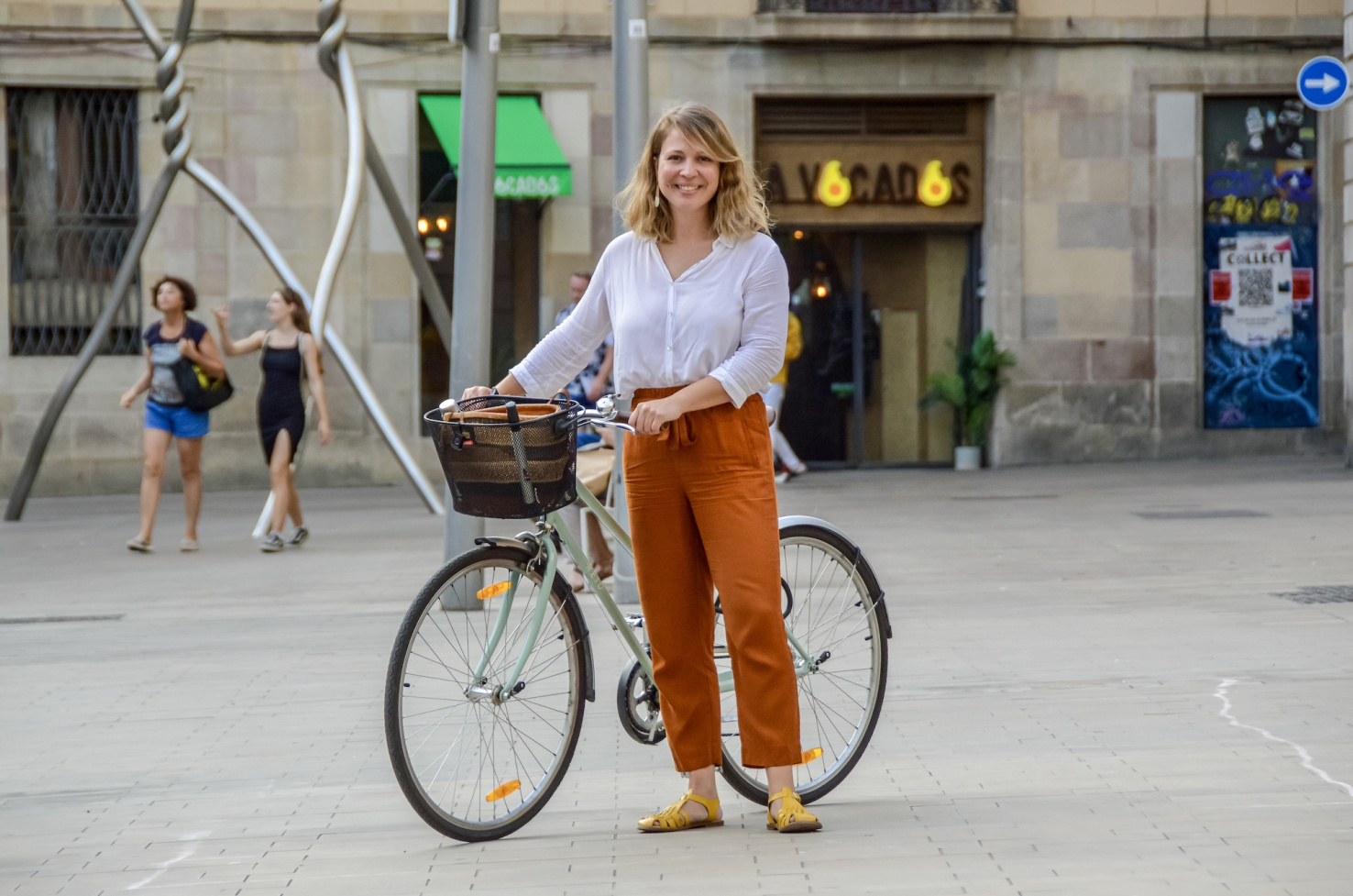 Janet Sanz in Barcelona, Spain leaning against bicycle.