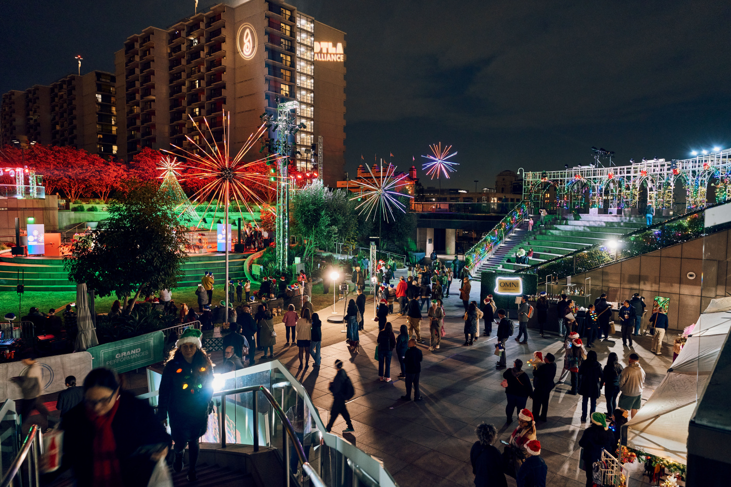 Crowd in downtown Los Angeles amphitheater at night with lighting art installations.