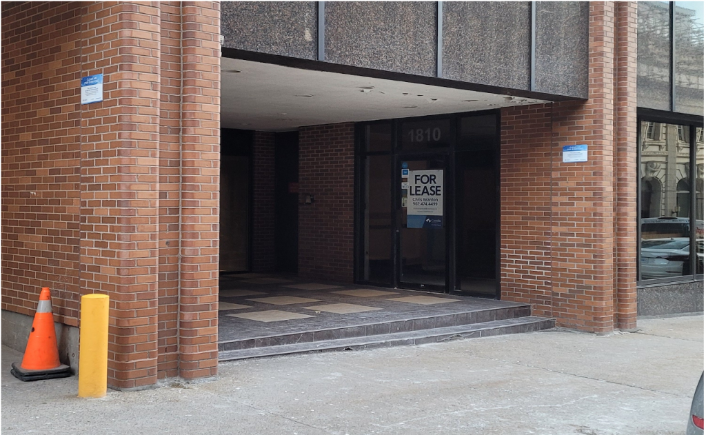 A dark entryway for a building includes a sign that reads "For Lease."