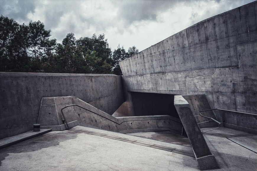 The angled staircase and entryway into a concrete building in the brutalism style.