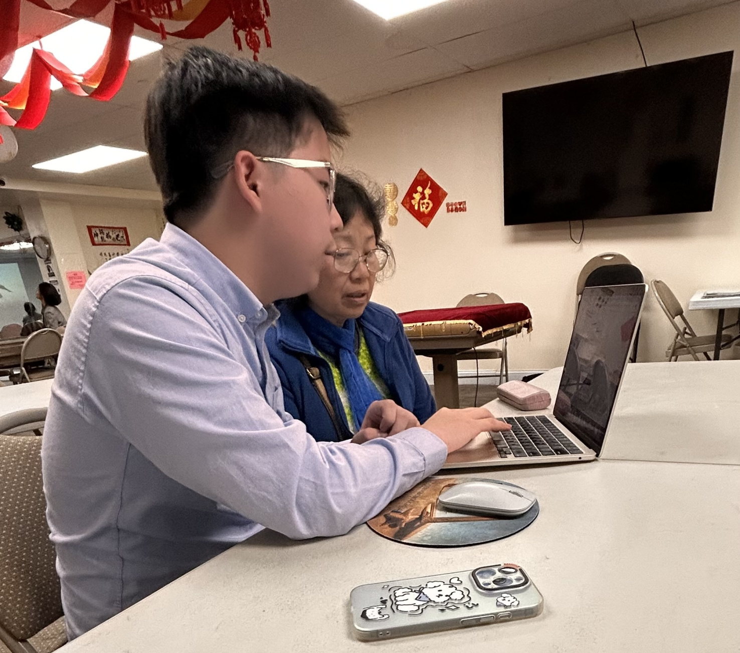 Tianli helps Chinese seniors understand the NYC housing assistance process. Image: Tianli Cheng