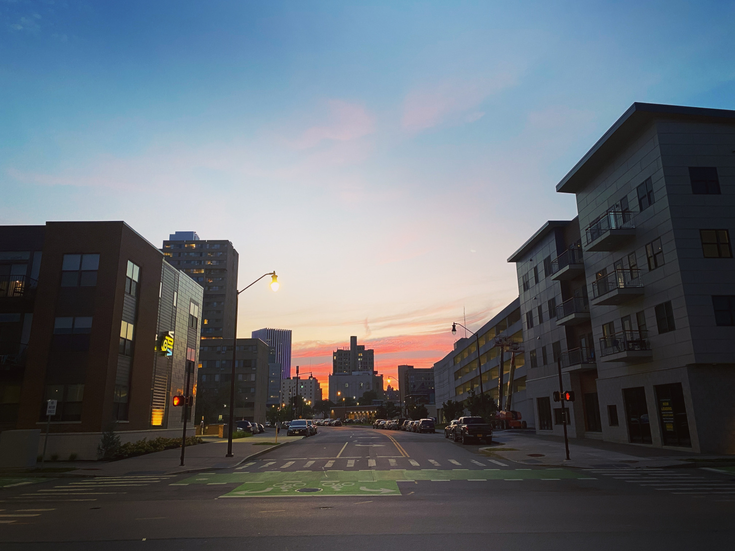 The sun setting over a city. Crosswalks and bike lanes are visible.