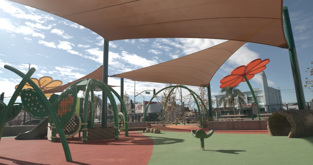 A colorful playground in a park surrounded by commercial properties.
