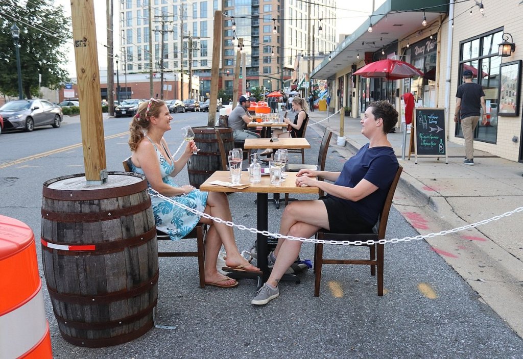 Two people sitting at table in outdoor dining setup at winery in SIlver Spring, Maryland.