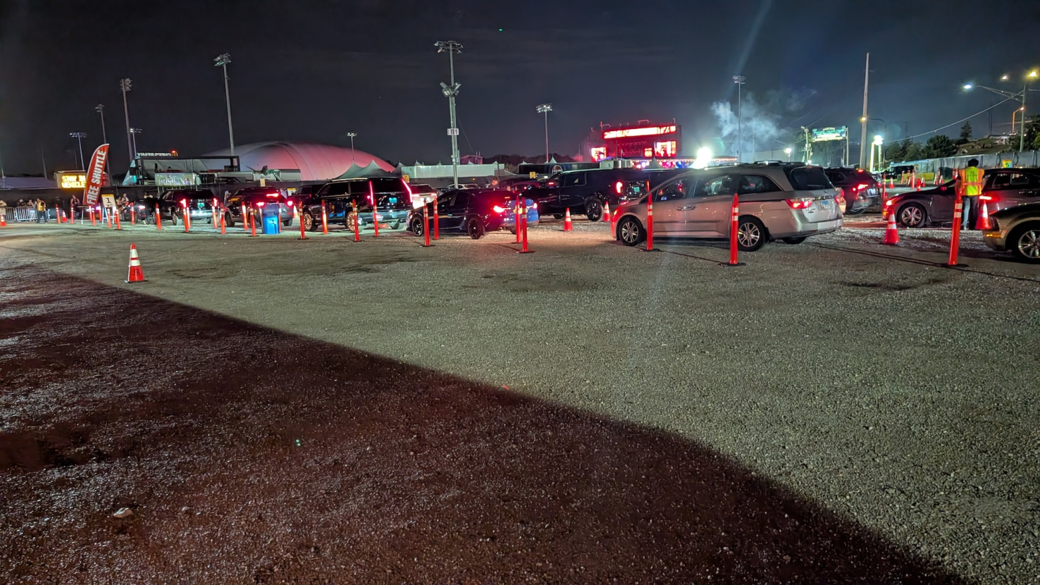 Cars waiting in line for parking at sports stadium.