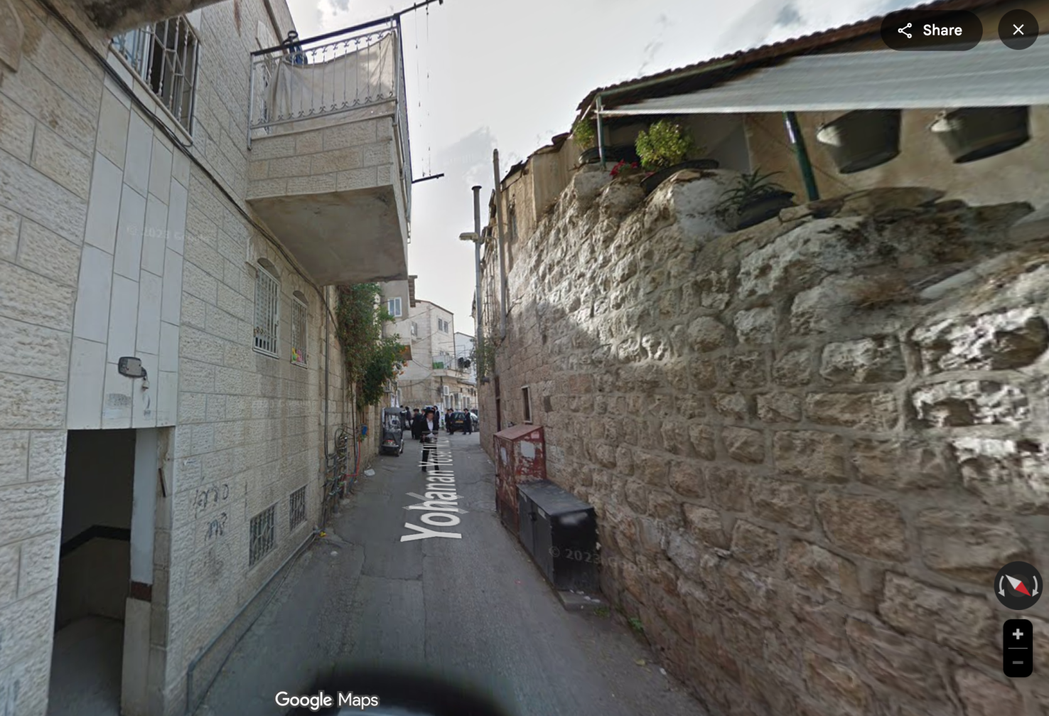 A narrow street with light-colored stone buildings in Jerusalem