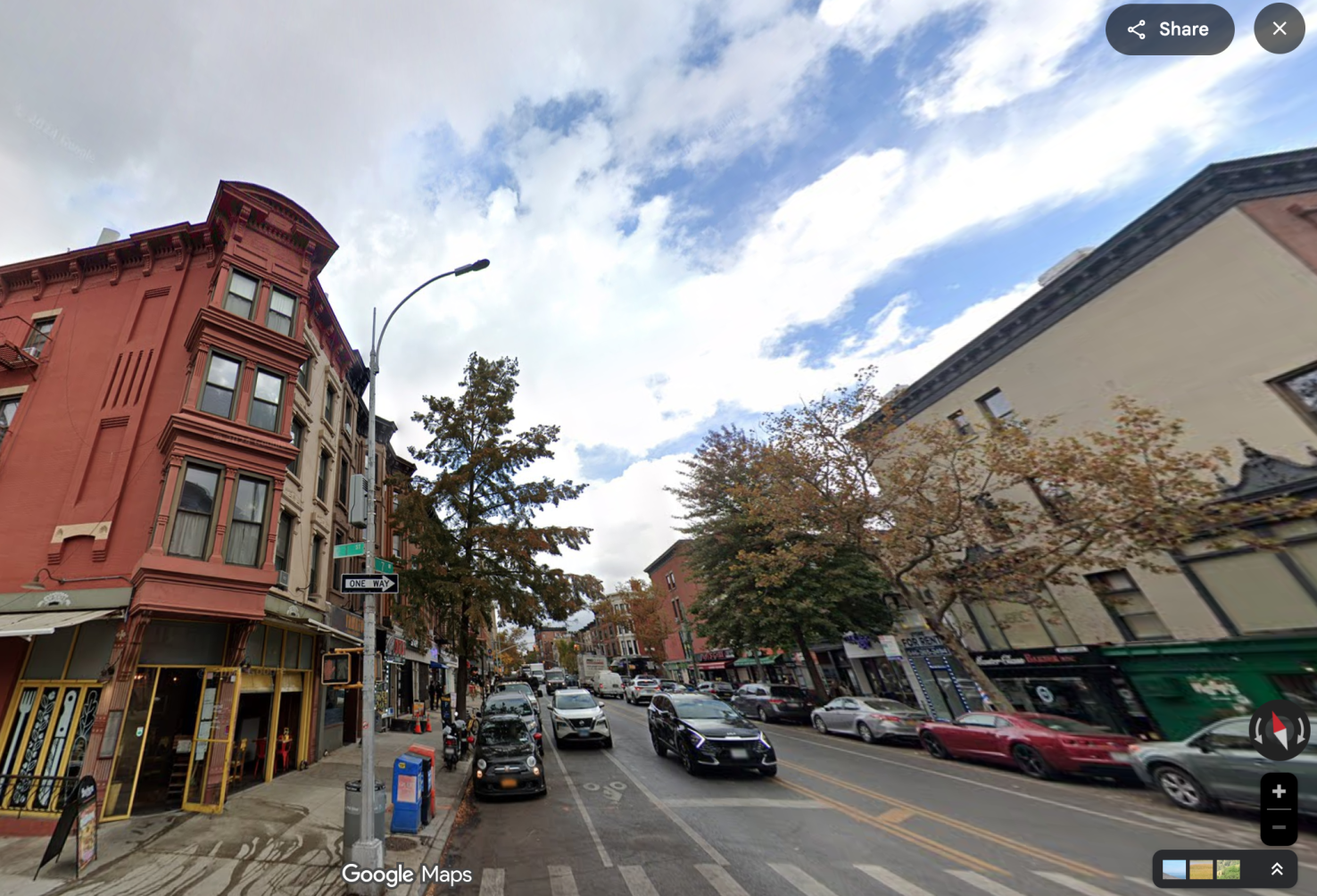 A red building on the corner of a brooklyn street