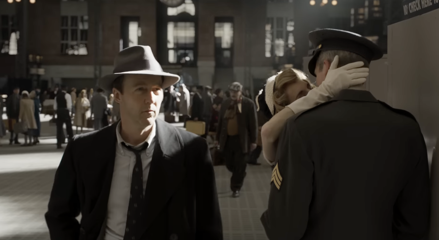 Screen shot of Edward Norton walking through busy transit station in Motherless Brooklyn.