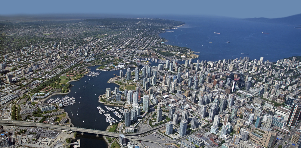 An aerial image of Downtown Vancouver, British Columbia and surrounding city ad mountains.