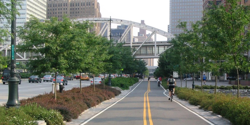 An image of West Side Boulevard in Manhattan, New York shows a protected bike lane along side the cars on the street.