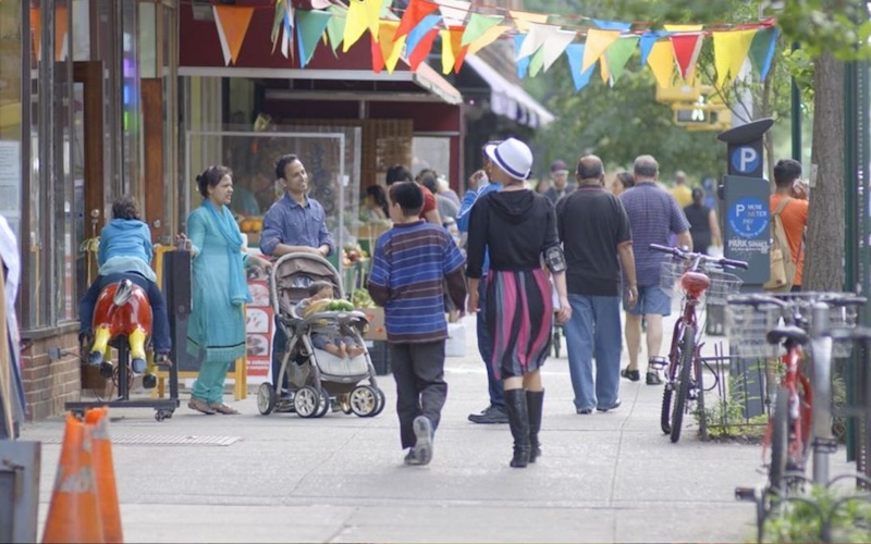 People walking down busy sidewalk.