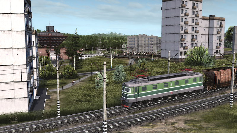 Screenshot from Workers and Resources: Soviet Republic video game of light rail car on track in foreground with Soviet-style apartment buildings in the background.