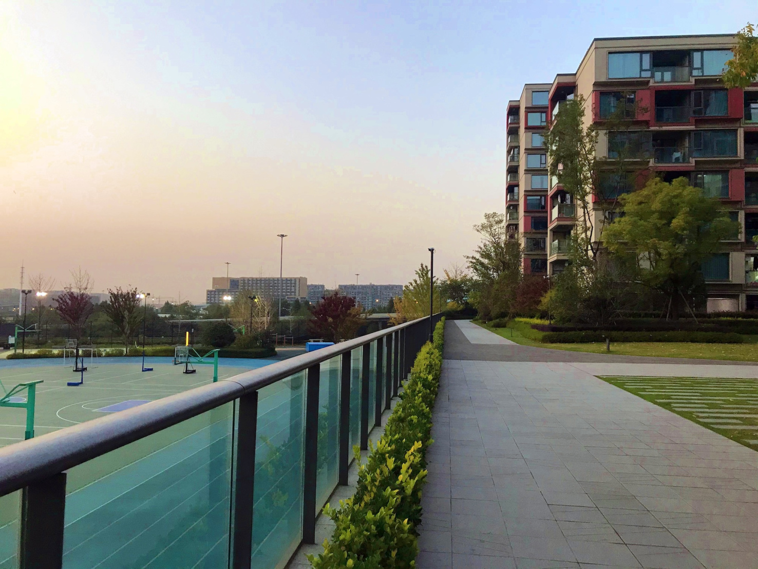 Apartment buildings next to green school basketball courts in China.