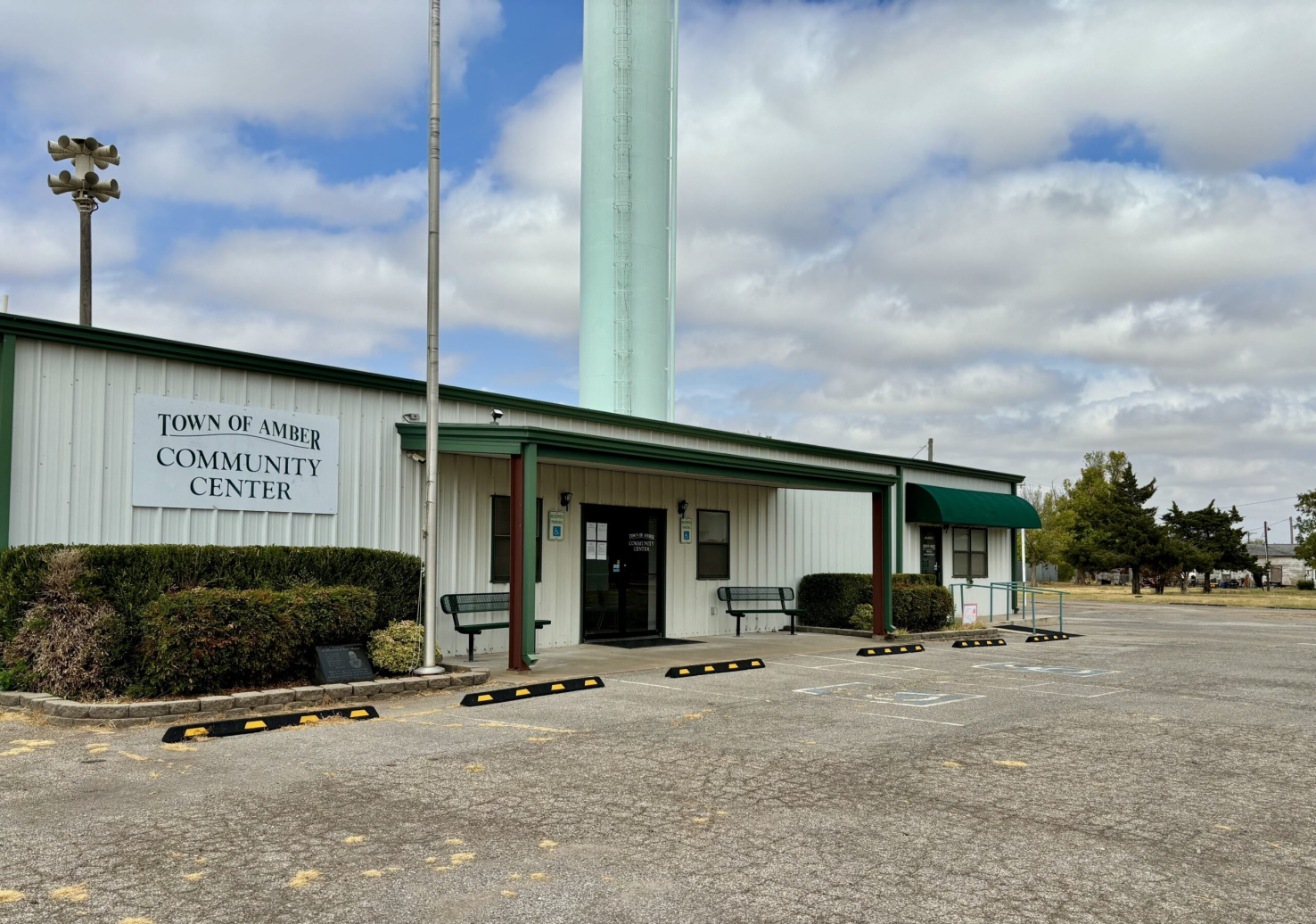 the town of amber community center, a short white building with dark green trim.