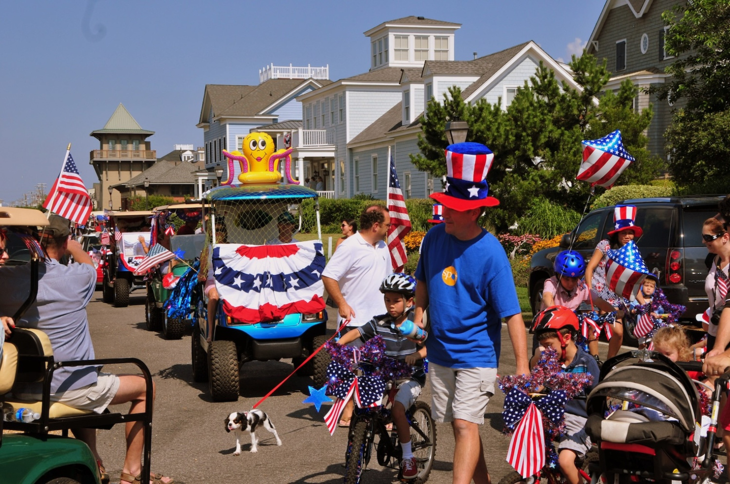People in patriotic accessories in decorated golf carts on street in East Beach, Norfolk, Virginia during 4th of July festivities.