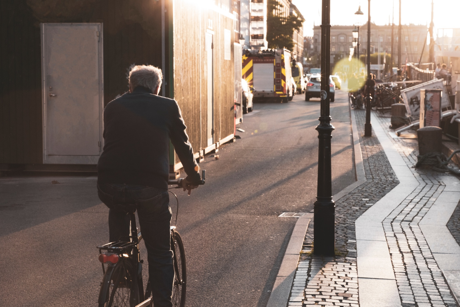 Elder man driving bike in Copenhagen, Denmark, Nyhavn background.