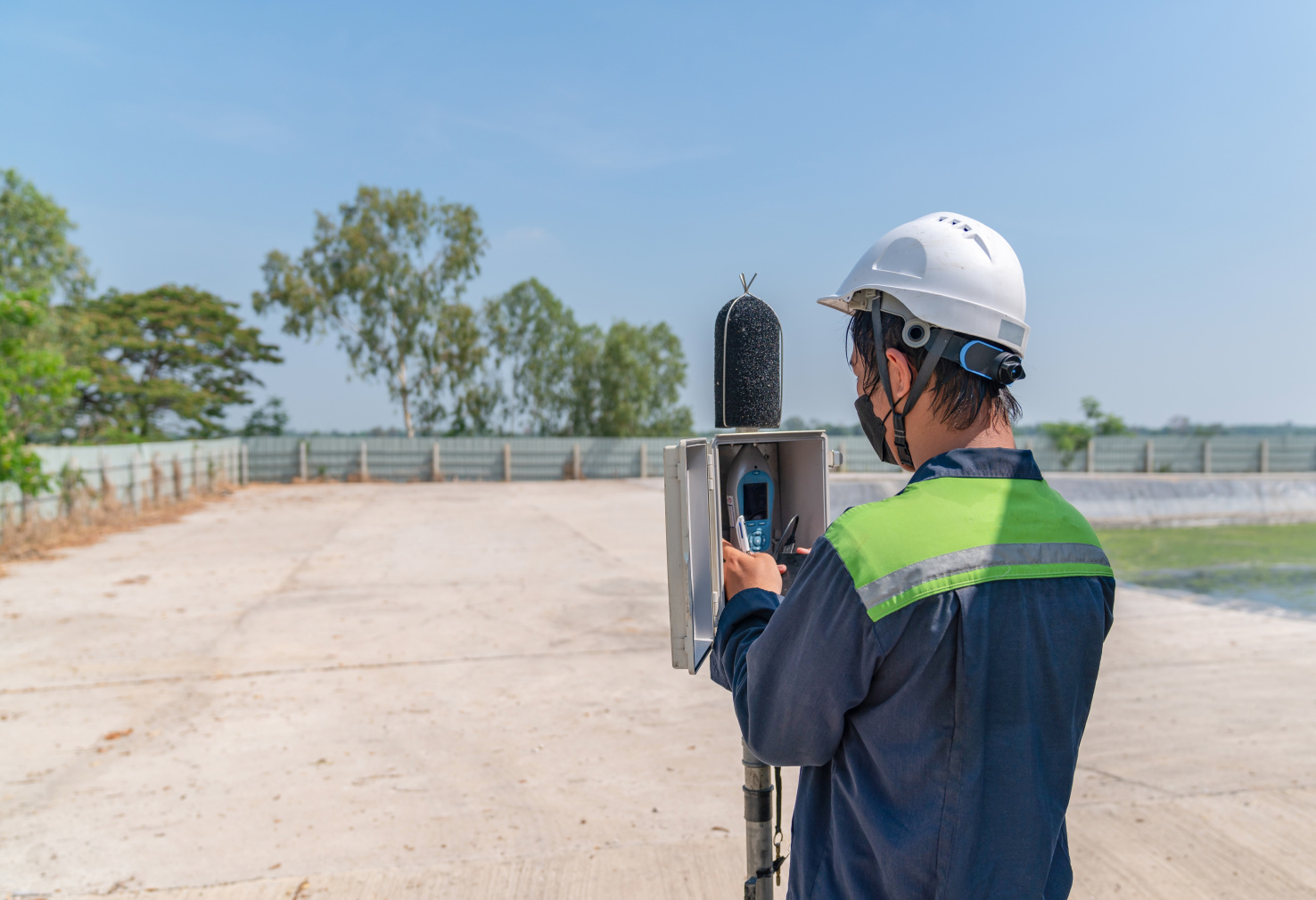 An environmental officer sets up a sound measuring system.