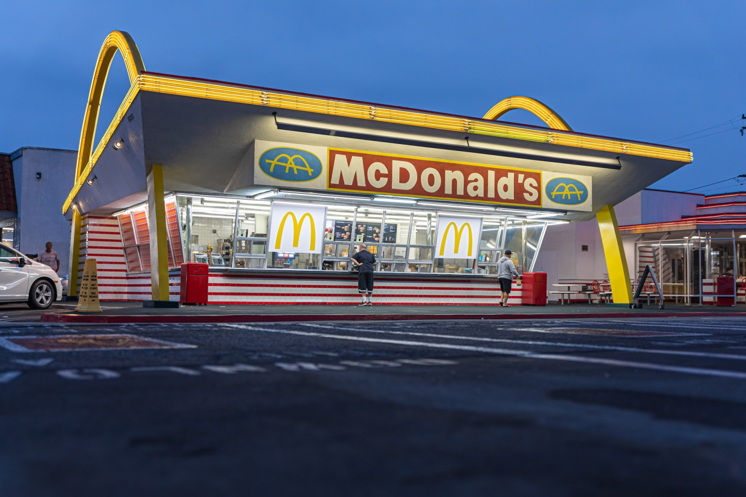 Vintage McDonald's building with golden arches on either side in Downey, California.