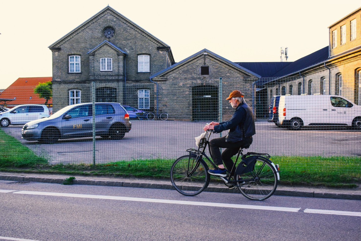 Old man riding a bike on road towards the sunny sunset sky.