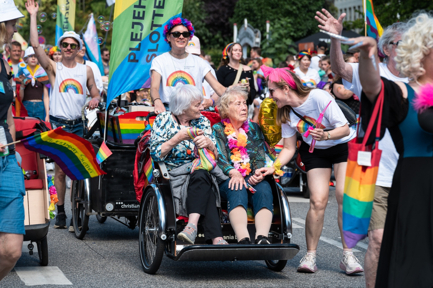 Care-home residents ride in a cycle rickshaw with volunteers during the Copenhagen Pride parade.