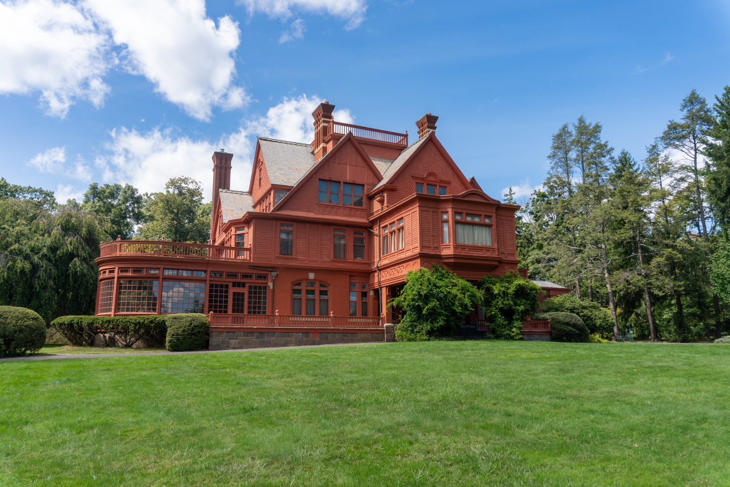 A large, orange house under a clear blue sky in a grassy park.