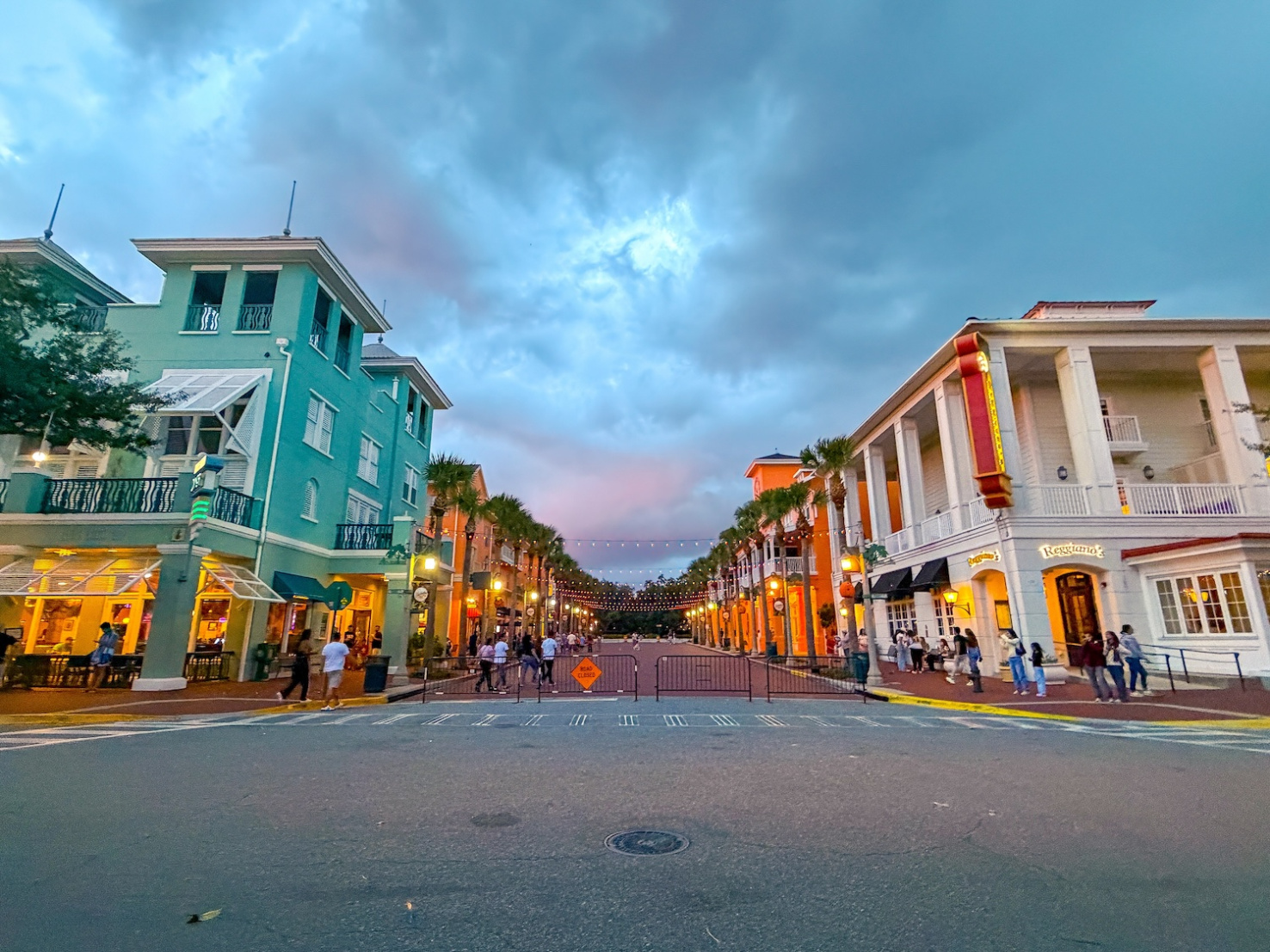 Commercial street in Celebration, Florida with colorful buildings and string lights at dusk.