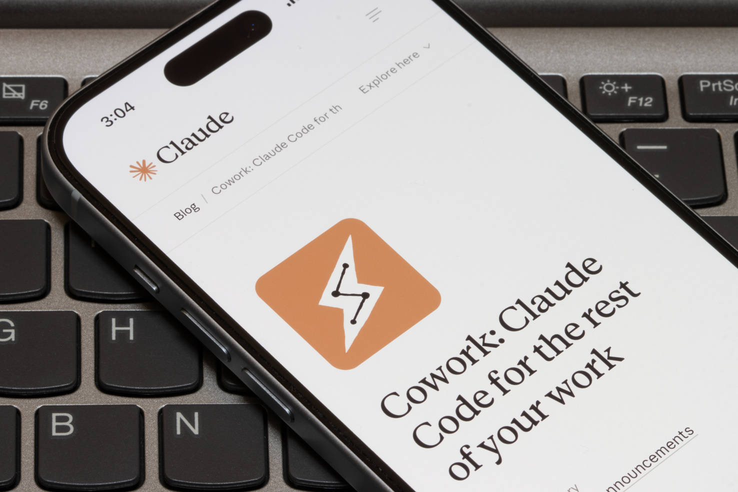 A phone with text reading "Cowork: Claude code for the rest of your work"