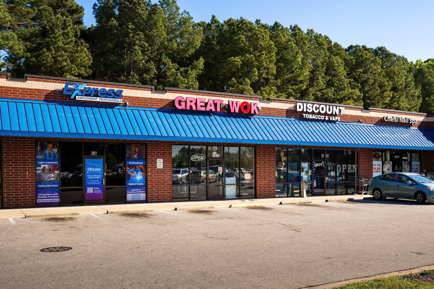 Strip mall in brick building with staffing agency, Chinese restaurant, vape shop, and nail spa.