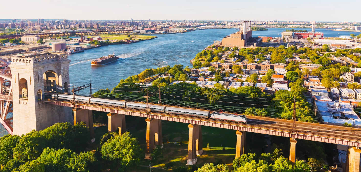 The Hell Gate bridge in New York City with a train passing over it.