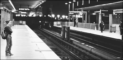 Image: A lone woman waits for a train.