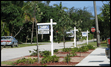 Photo: Real estate signs on a suburban block.