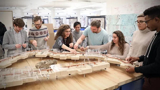 Students interacting in a group with a wooden diorama